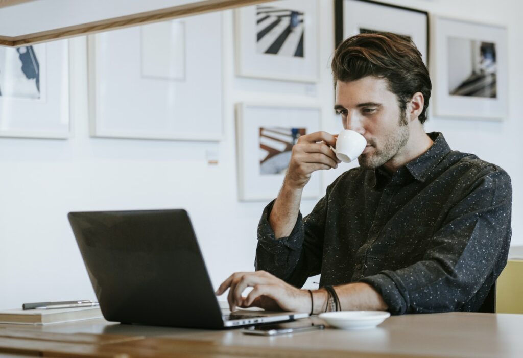 Hombre en su computadora buscando información sobre cómo construir su marca personal.