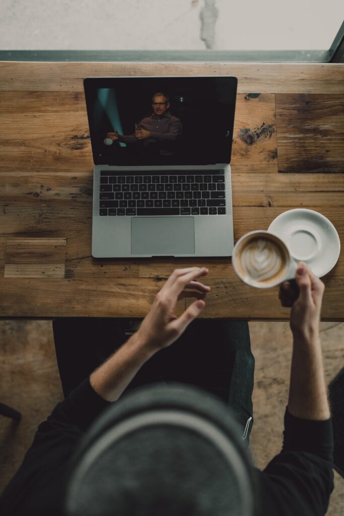 hombre bebiendo café mientras ve un video de marca. 