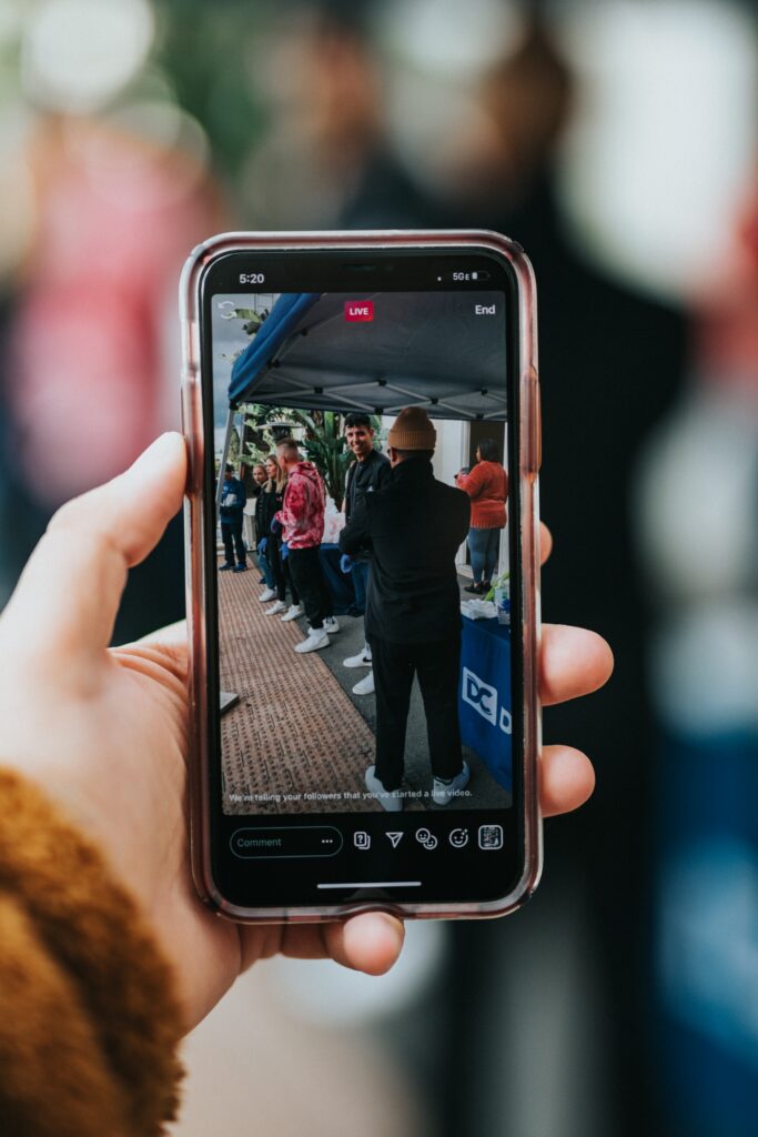 Hombre usando su teléfono celular para grabar videos promocionales.