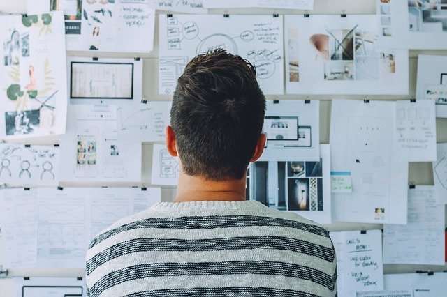 Una foto de un hombre trabajando en una estratégia frente a un tablero con ideas para un artículo de marketing digital.