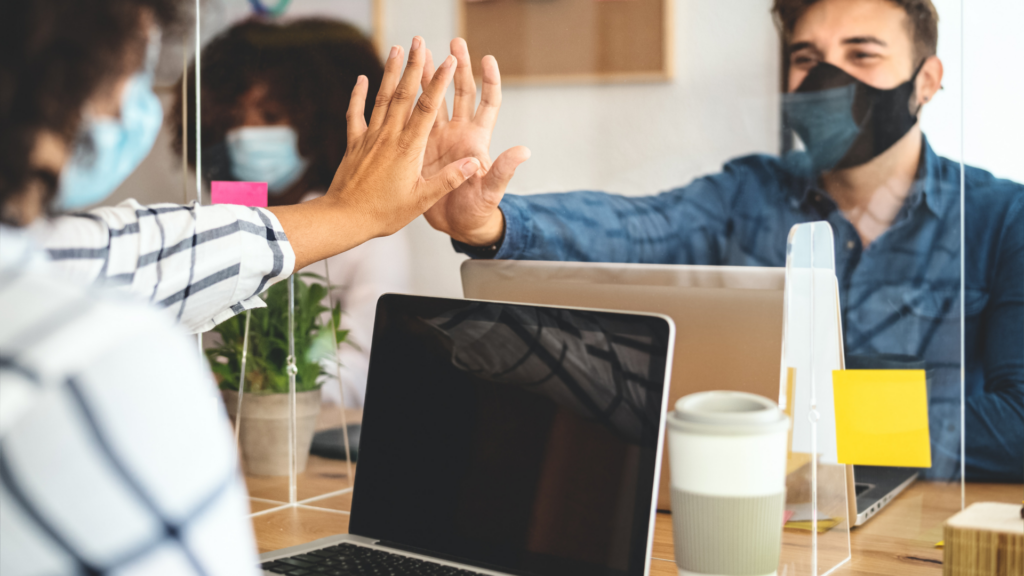 An image from an image bank depicting people at work during the pandemic era for an article about the importance of digital marketing in times of pandemic.