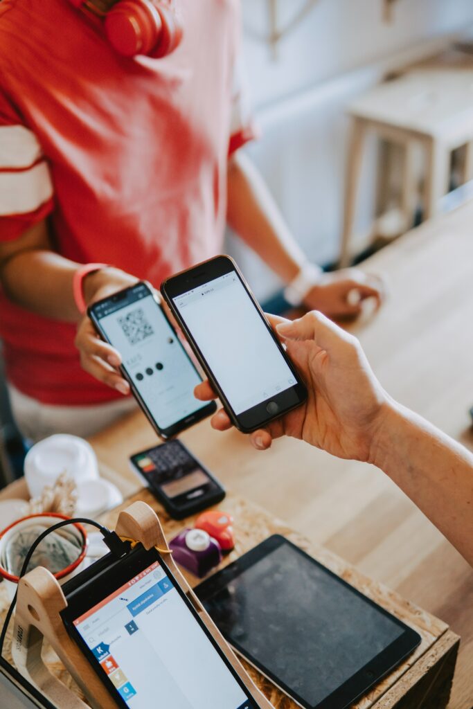 stock image of people making contactless payments using smartphones.