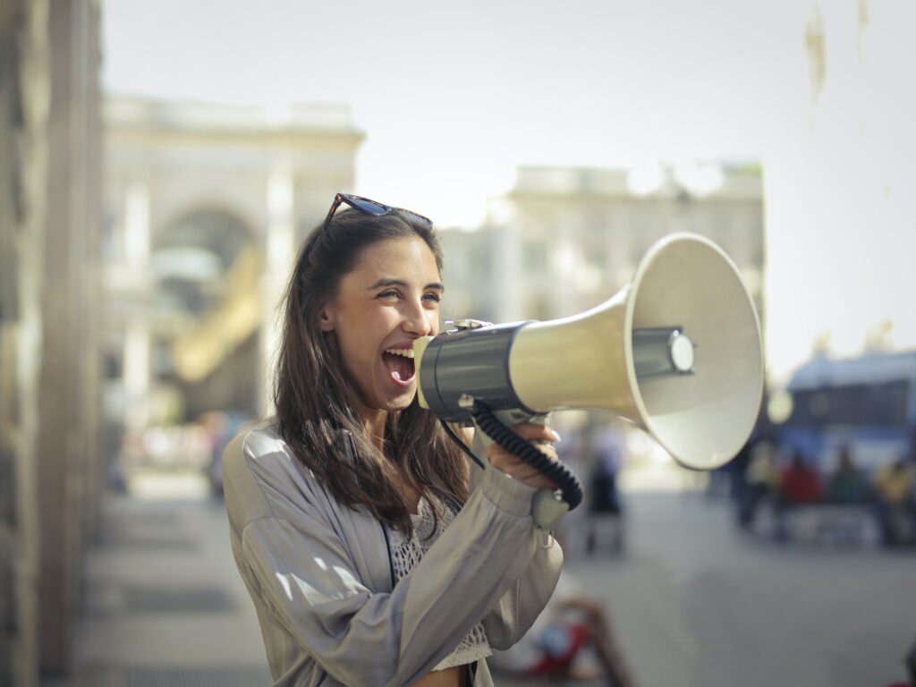 Stock image of a woman with a megaphone for an article about SEO tips for a blog.